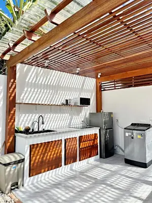 an outdoor kitchen with a wooden pergola at 2BR Pool Villa&Garden - Bali style by La Perla Phuket Rawai in Ban Saiyuan (1)