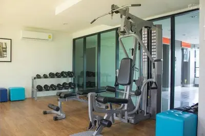 a gym with a treadmill and a chair and weights at 中央公寓 1 bed & Twin beds in Ban Rangeng