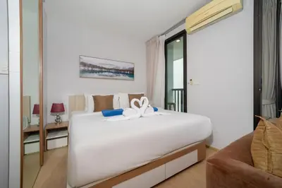 a bedroom with a large white bed with a bow on it at Private apartment Zcape2 near Boat Avenue in Bang Tao Beach