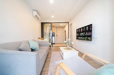 a living room with a couch and a table at Laguna BangTao Beach Skypark Apartment in Phuket Town
