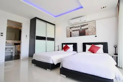 a bedroom with two beds with red pillows at Luxury Rooftop Penthouse in Kamala Beach