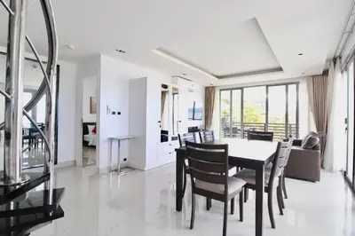a dining room and living room with a table and chairs at Luxury Rooftop Penthouse in Kamala Beach