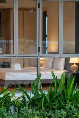 a room with a bed and some plants at 5 Bdr 18 meter Pool villa in Laguna Phuket in Phuket Town