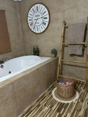 a large clock on the wall above a tub in a bathroom at Villa KEWALYN in Chalong