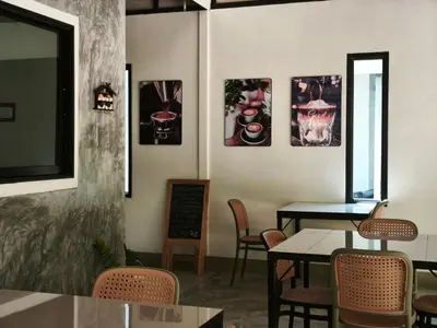 a dining room with tables and chairs and pictures on the wall at The Secret Garden Koh Yao Yai in Ko Yao Yai