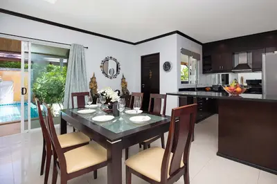 a kitchen and dining room with a table and chairs at Tropical 3BR Pool Villa Prima, just 5min Drive to NaiHarn and Rawai Beach in Rawai Beach