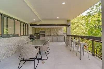 a patio with a table and chairs on a balcony at Ray Ray Villa by G Estate Phuket in Kata Beach
