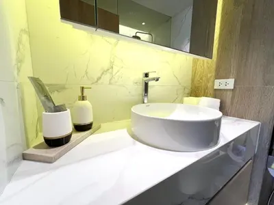 a bathroom with a white sink and a mirror at Stylish 1 Bedroom Apartment with Golf View, Steps from Bang Tao Beach, Allamanda Laguna in Bang Tao Beach