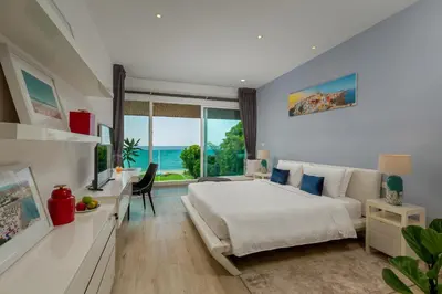 a bedroom with a bed and a view of the ocean at Summer Estate Villa in Pilai Beach
