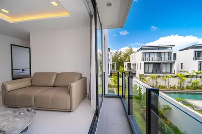 a living room with a couch and a balcony at 4bdr pool villa in Laguna Park 2 in Phuket Town