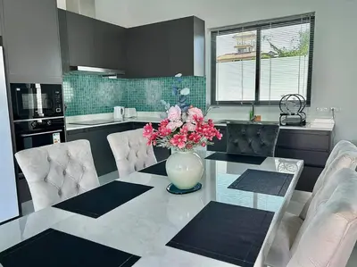 a kitchen with a table with a vase of flowers on it at Costa Lota villa, brand new, 3 bedroom, in rawai V35 in Rawai Beach
