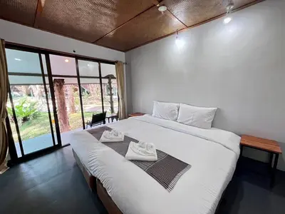 a bedroom with a large bed with two towels on it at Long Beach Club Krabi in Ban Nong Thale