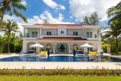 a villa with a swimming pool and palm trees at Carpe Diem Beach Villa in Natai Beach