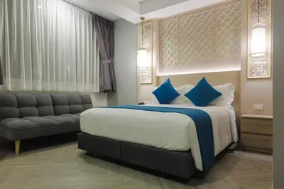 a hotel room with a bed and a couch at Kamala Havana Hotel and Cafe in Kamala Beach