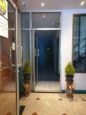 an entrance to an office building with two potted plants at Desa Phuket in Phuket Town
