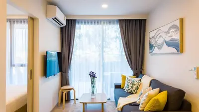 a living room with a couch and a window at Апартаменты в Laguna Skypark с террасой in Bang Tao Beach