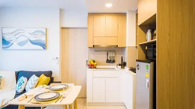 a small kitchen with a table and a refrigerator at Апартаменты в Laguna Skypark с террасой in Bang Tao Beach