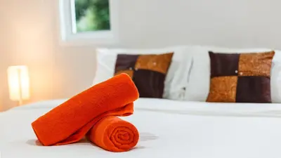a pile of orange towels sitting on a bed at Bangtao Guest House in Bang Tao Beach