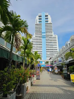 a street with palm trees and tall buildings at Patong Tower Apartment in Patong Beach