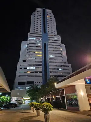 a tall white building at night with a parking lot at Patong Tower Apartment in Patong Beach