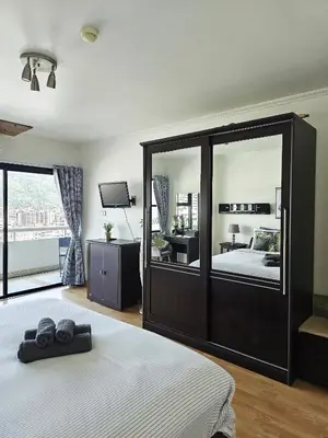 a bedroom with a large bed with a mirror at Patong Tower Apartment in Patong Beach