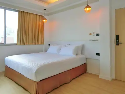 a bedroom with a bed with white sheets and pillows at Sira Boutique, Patong in Patong Beach