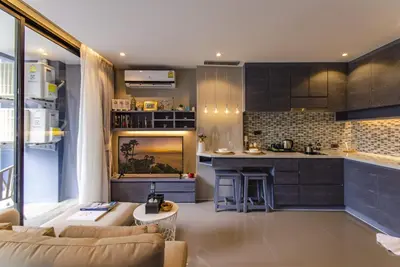 a living room with a couch and a kitchen at Stylish apartments Kamala CityGate in Kamala Beach