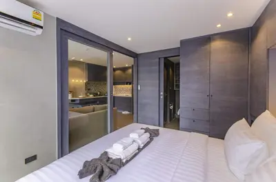a bedroom with a white bed and a bathroom at Stylish apartments Kamala CityGate in Kamala Beach