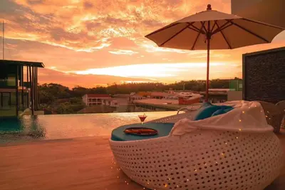a chair with a table and an umbrella next to a pool at Modern style 1BR Condo close to Kata beach in Kata Beach