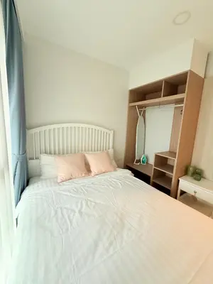 a bedroom with a large white bed with pink pillows at Skypark Laguna Phuket in Bang Tao Beach