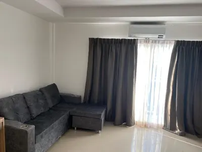 a living room with a couch and a window at Studio Apartment in Phuket Town