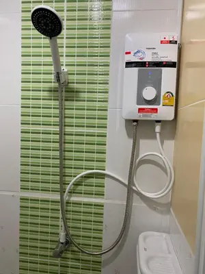 a bathroom with a shower head and a toilet at Studio Apartment in Phuket Town