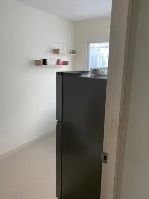 a black refrigerator in a kitchen with a sink at Studio Apartment in Phuket Town
