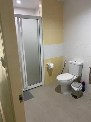 a bathroom with a toilet and a walk in shower at Studio Apartment in Phuket Town