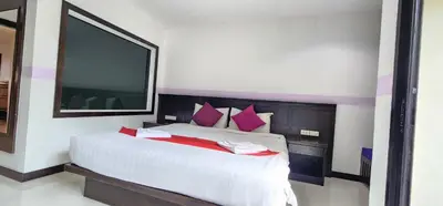 a bedroom with a large white bed with red pillows at Diamond Crown Hotel in Patong Beach