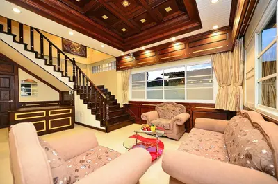 a living room with two couches and a staircase at Group Getaway Patong House in Patong Beach