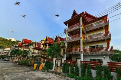 a tall building with red roofs on a street at Group Getaway Patong House in Patong Beach