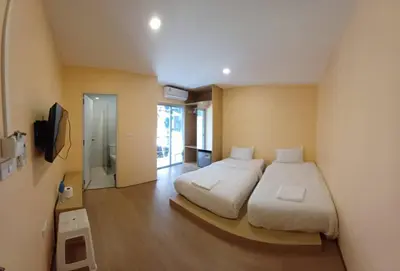 a bedroom with two beds and a television in it at Lucky Seven Patong in Patong Beach