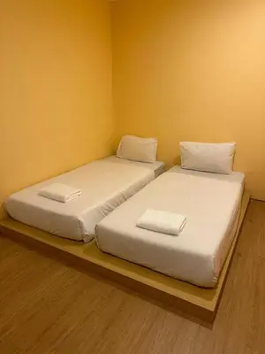 two beds sitting next to each other in a room at Lucky Seven Patong in Patong Beach