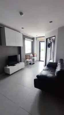 a living room with a black leather couch and chairs at 1bed in Chalong