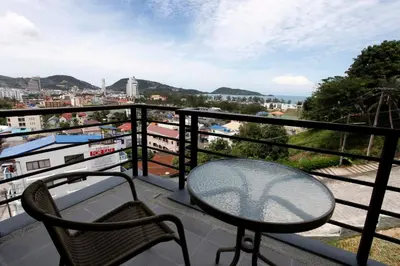 a table and chair on a balcony with a view at Sea view apartment at The Unity by Lofty in Patong Beach