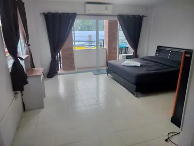 a bedroom with a bed and a large window at the three pyramids in Phuket Town