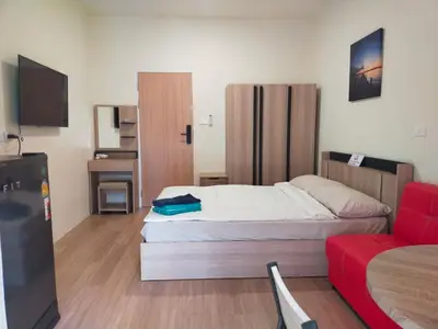 a bedroom with a bed and a red couch at Bonanza Patong Beach1 100m to Beach Moon Room in Patong Beach