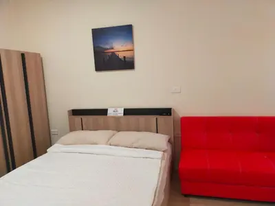 a bedroom with two beds and a red couch at Bonanza Patong Beach1 100m to Beach Moon Room in Patong Beach