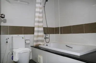 a bathroom with a tub and a toilet and a sink at Diamond Crown in Patong Beach