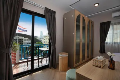a room with a large window with a view of a balcony at Tuna Boutique Hotel Patong in Patong Beach