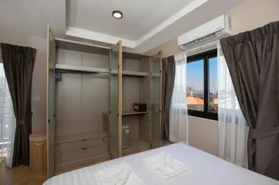a bedroom with a white bed and a window at Tuna Boutique Hotel Patong in Patong Beach