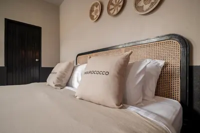 a bed with pillows on it with clocks on the wall at Marococco Private Pool Villa in Ban Mut Dok Khao