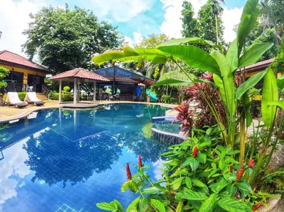 a swimming pool in a resort with trees and plants at beautiful pool house in Patong Beach