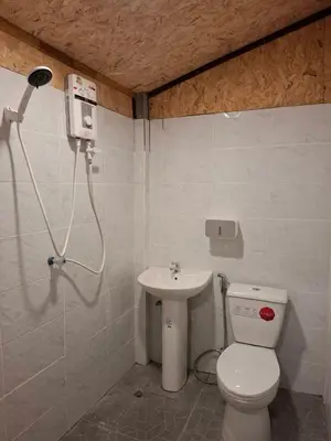a bathroom with a toilet and a sink at ฟาดิลบังกะโล Fadel bungalow in Ban Lo Pa Ret